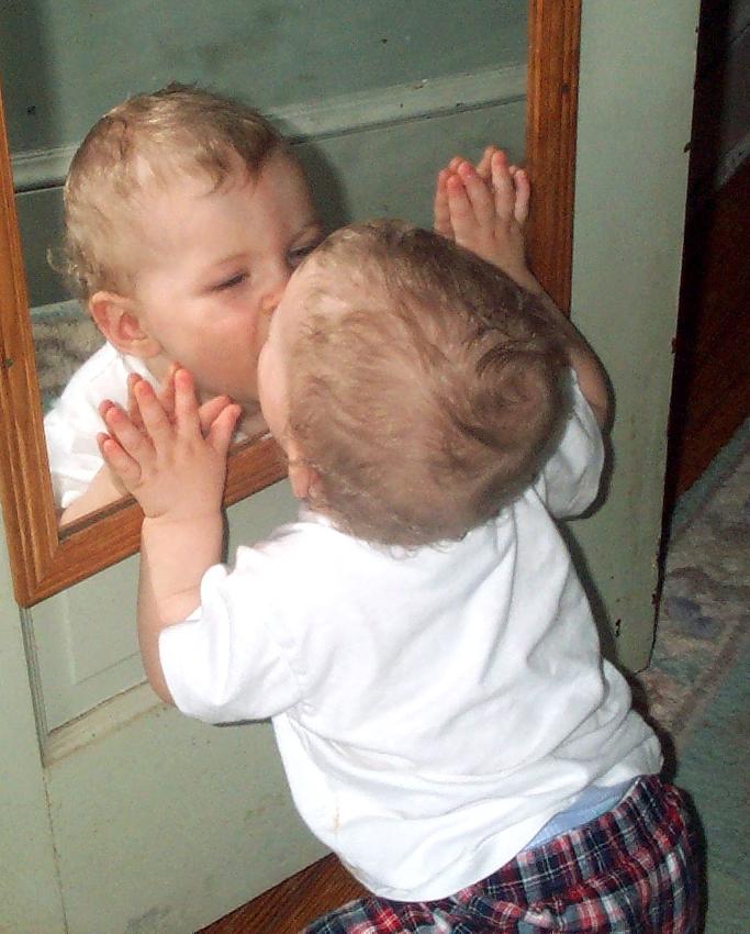 鏡を興味深く見つめる子供